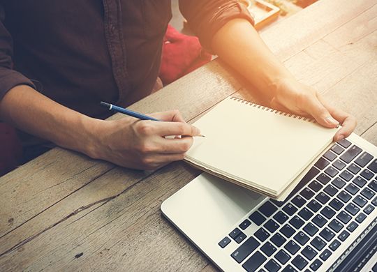 Man write on notebook with laptop vintage tone.